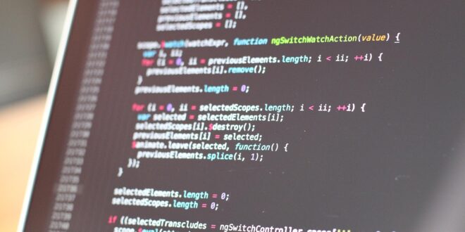 laptop screen with image of coding on it that is largely unreadable but resembles a set of computer code