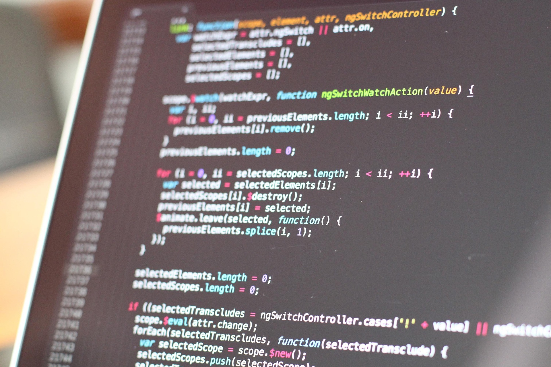 laptop screen with image of coding on it that is largely unreadable but resembles a set of computer code