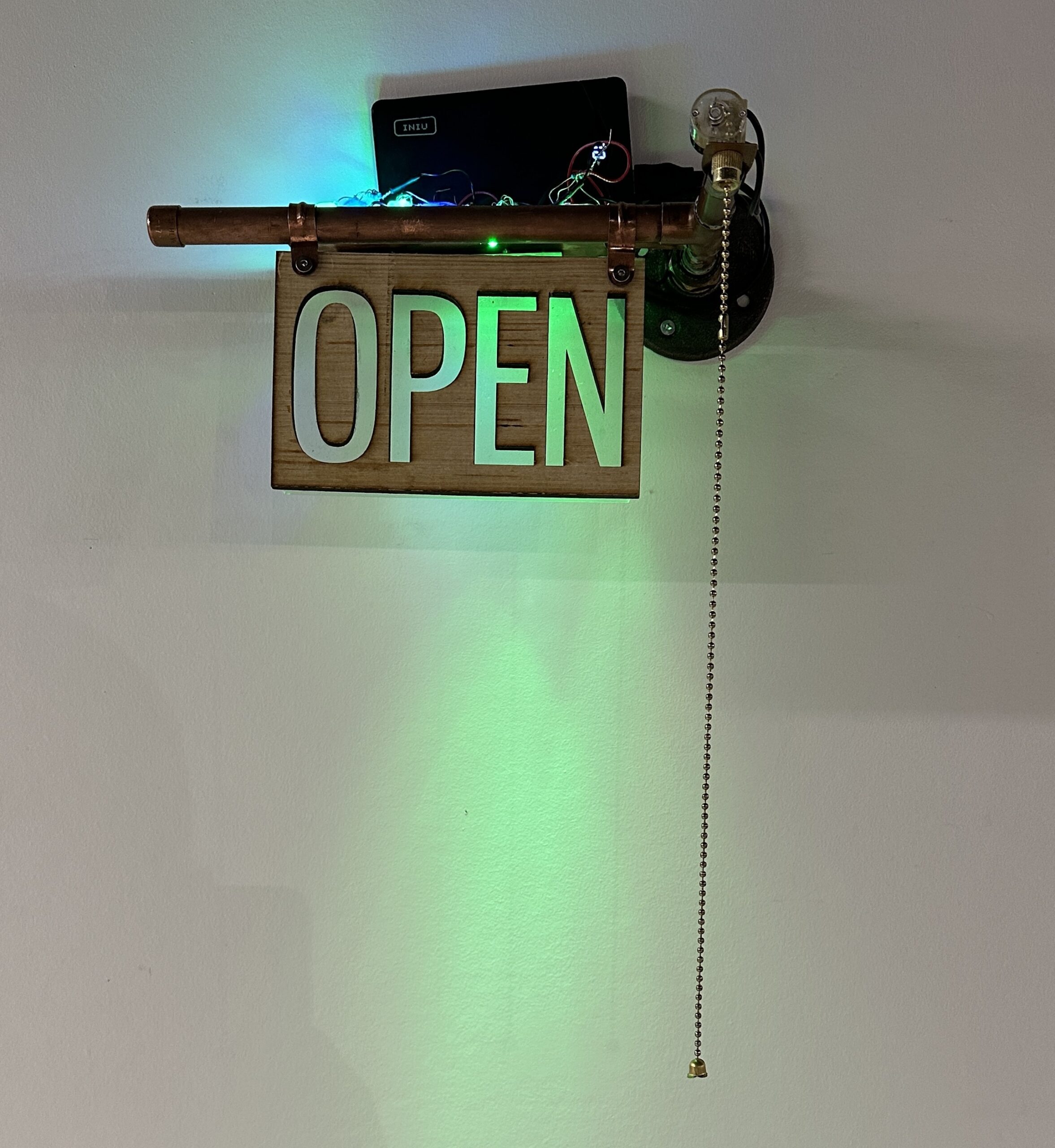 Environment Machine Shop - OPEN Green lit sign with a pull string - the sign says OPEN and is mounted on a white wall