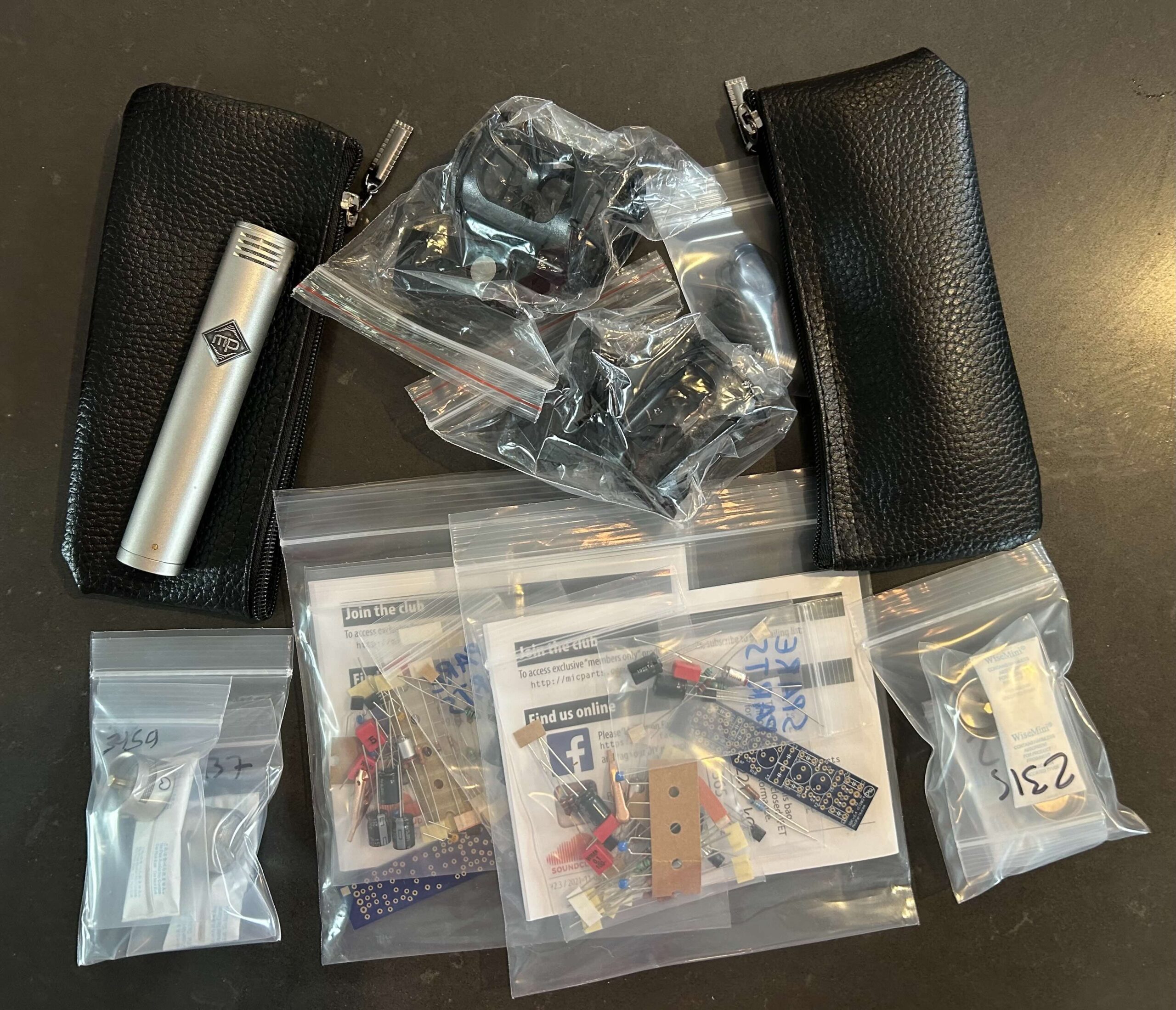 A collection of parts to build two small condenser microphones