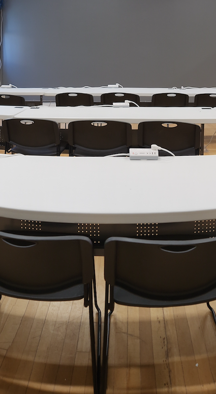 CU Bubble view of an empty PIVOT space taken from the back. Black chairs are tucked in. There are three rows.