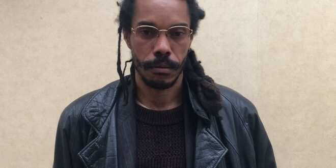photo of allan ballon against a beige wall wearing a black leather jacket