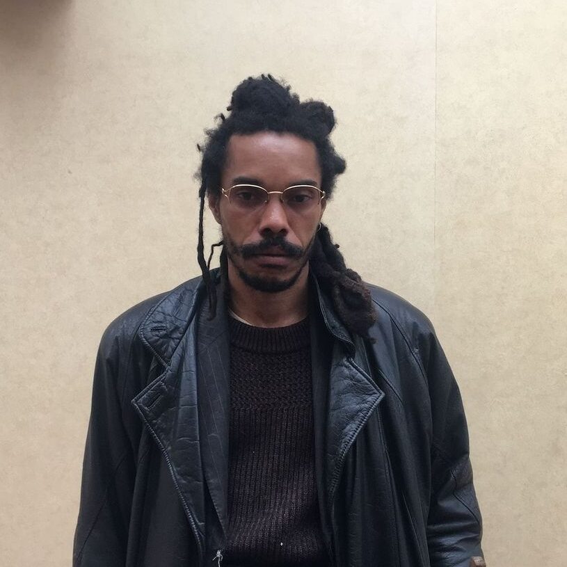 photo of allan ballon against a beige wall wearing a black leather jacket